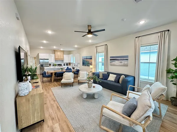 a living room with furniture a flat screen tv and a large window