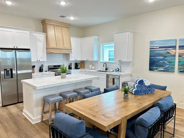 a kitchen with a table chairs refrigerator and cabinets