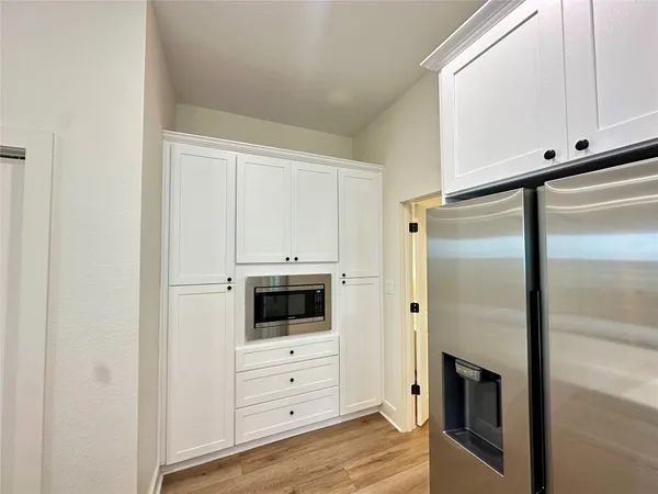 a kitchen with white cabinets and white appliances