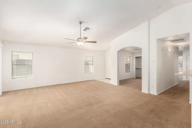 a view of a livingroom with wooden floor and a ceiling fan