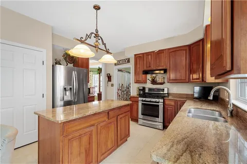 a kitchen with stainless steel appliances granite countertop a stove a sink dishwasher and a microwave oven with cabinets