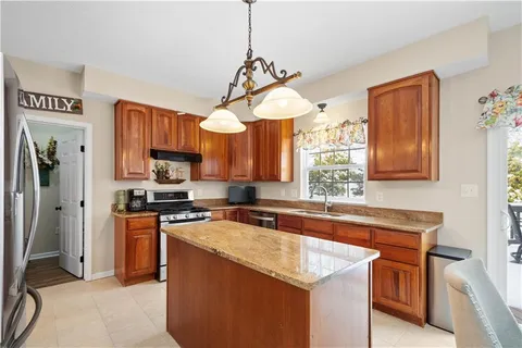 a kitchen with stainless steel appliances granite countertop a sink a stove and a refrigerator