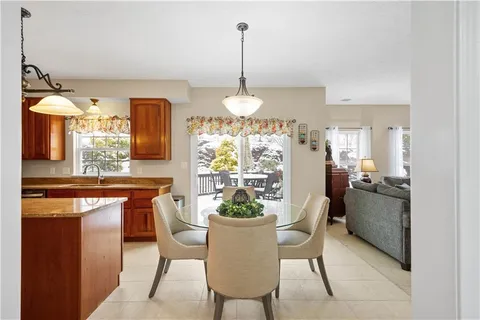 a dining room filled a chandelier and kitchen view