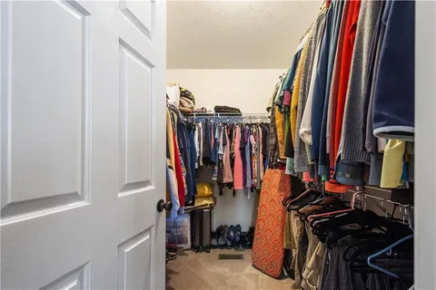 a view of walk in closet with clothes