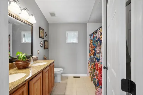 a bathroom with a sink a toilet and shower curtain