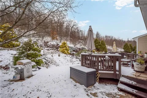 a view of a roof deck with couches and wooden fence