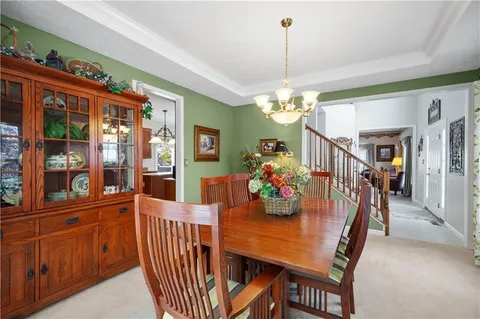 a dining room with furniture a chandelier and window