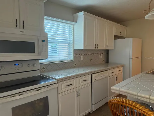 a kitchen with a refrigerator sink stove and cabinets