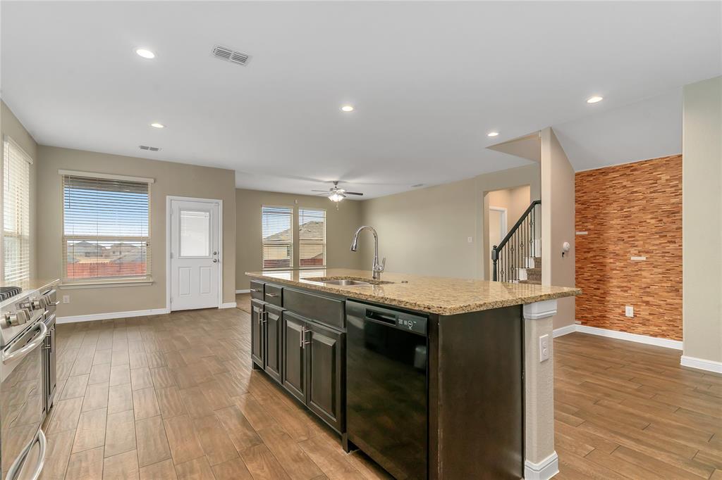 1102 Tiburon Trail Cleburne, TX 76033 - Photo 6 of 36 Kitchen featuring black dishwasher, a kitchen island with sink, light wood finished floors, gas range, and light stone countertops