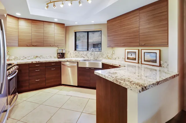 a kitchen with a granite countertop sink and cabinets