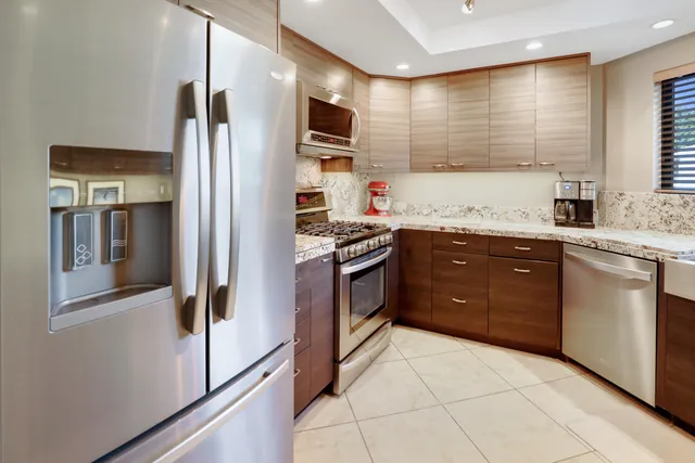 a kitchen with stainless steel appliances granite countertop a refrigerator and a sink