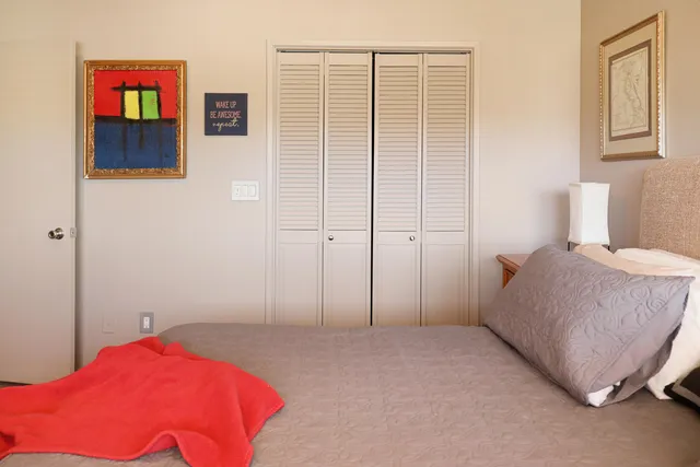 a bedroom with a bed and a potted plant