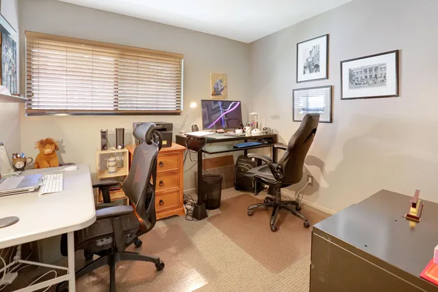 a view of a workspace with furniture and a window