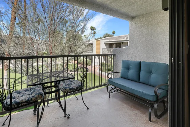 a balcony with furniture and a book shelf