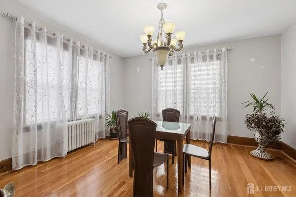 a kitchen with granite countertop a table chairs stove a refrigerator and cabinets