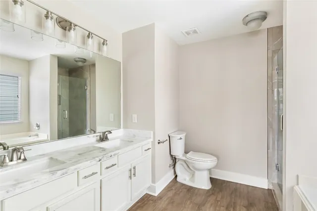 a bathroom with a granite countertop toilet a sink and a mirror