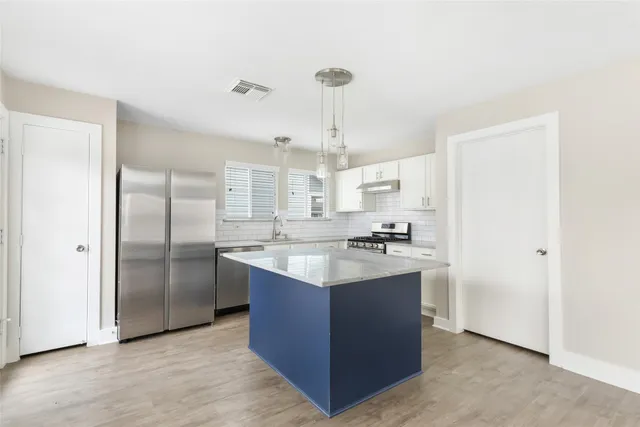 a kitchen with stainless steel appliances granite countertop a sink stove and refrigerator