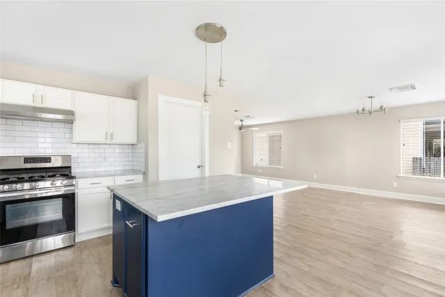 a kitchen with a stove and a wooden floor