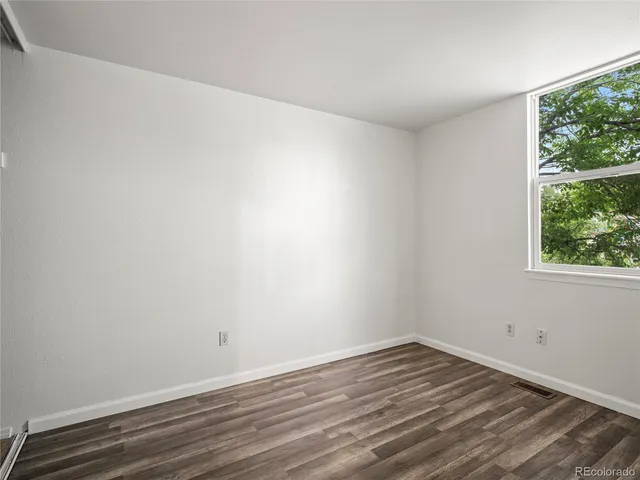 a view of a room that has wooden floor and large window