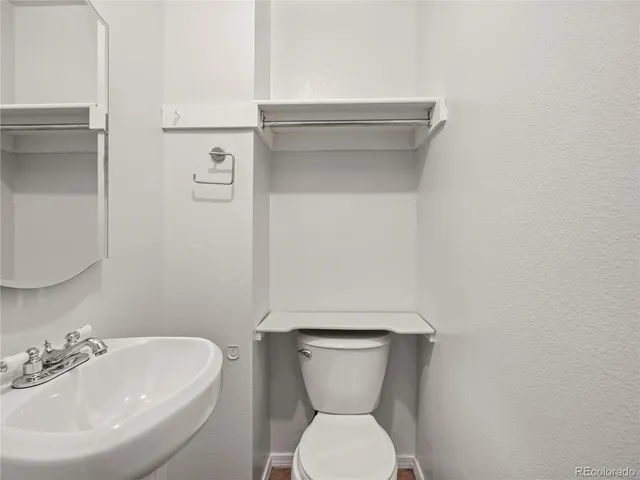 a bathroom with a toilet sink and mirror