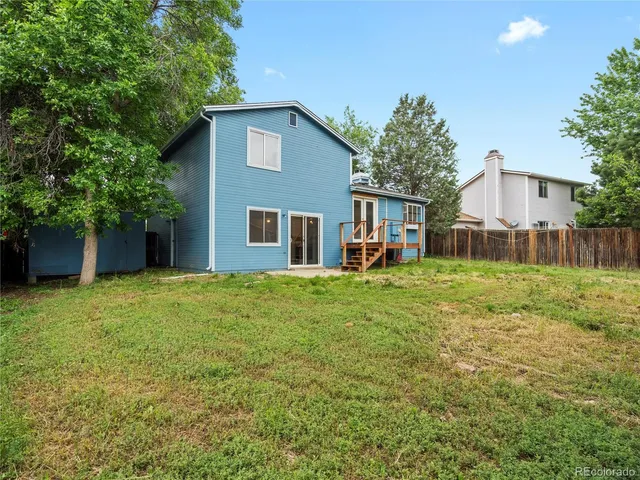a view of a house with backyard and a tree