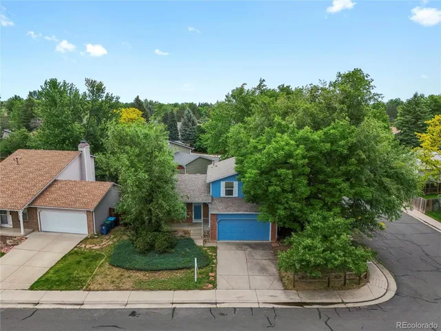 a front view of a house with a yard and trees