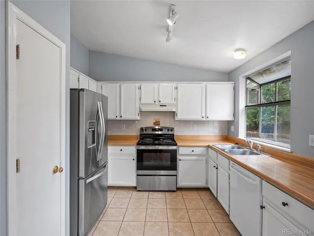 a kitchen with a stove sink and refrigerator