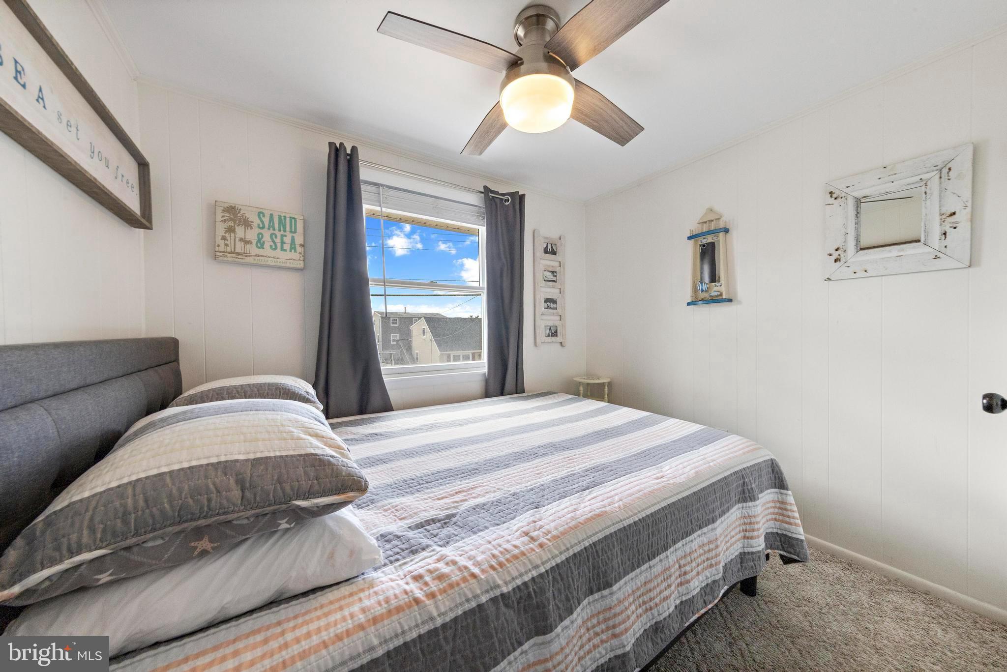 13 Joan Road, Unit 2 Long Beach Township, NJ 08008 - Photo 21 of 64 a bedroom with a bed and a chandelier