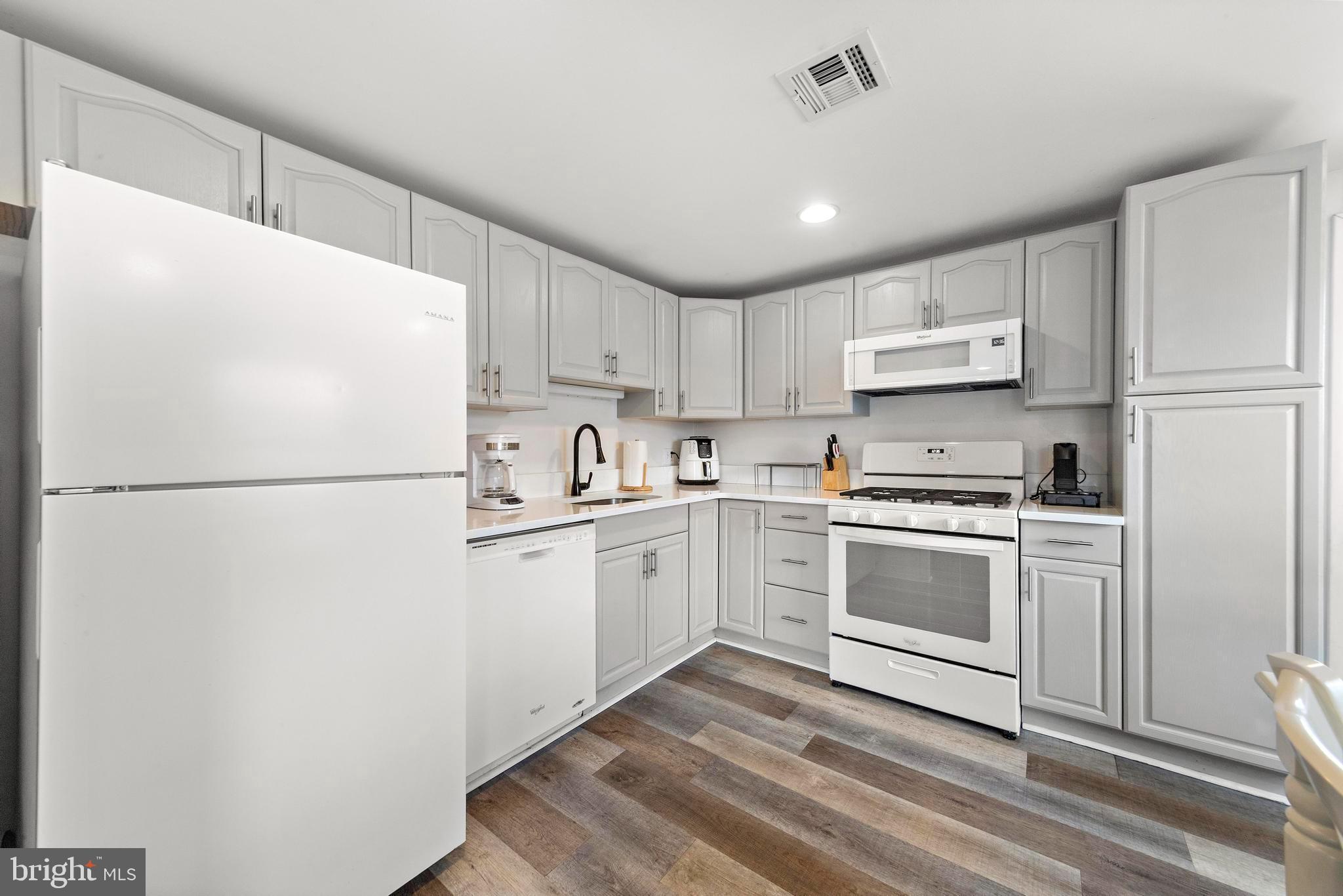 13 Joan Road, Unit 2 Long Beach Township, NJ 08008 - Photo 3 of 64 a kitchen with white cabinets and white appliances