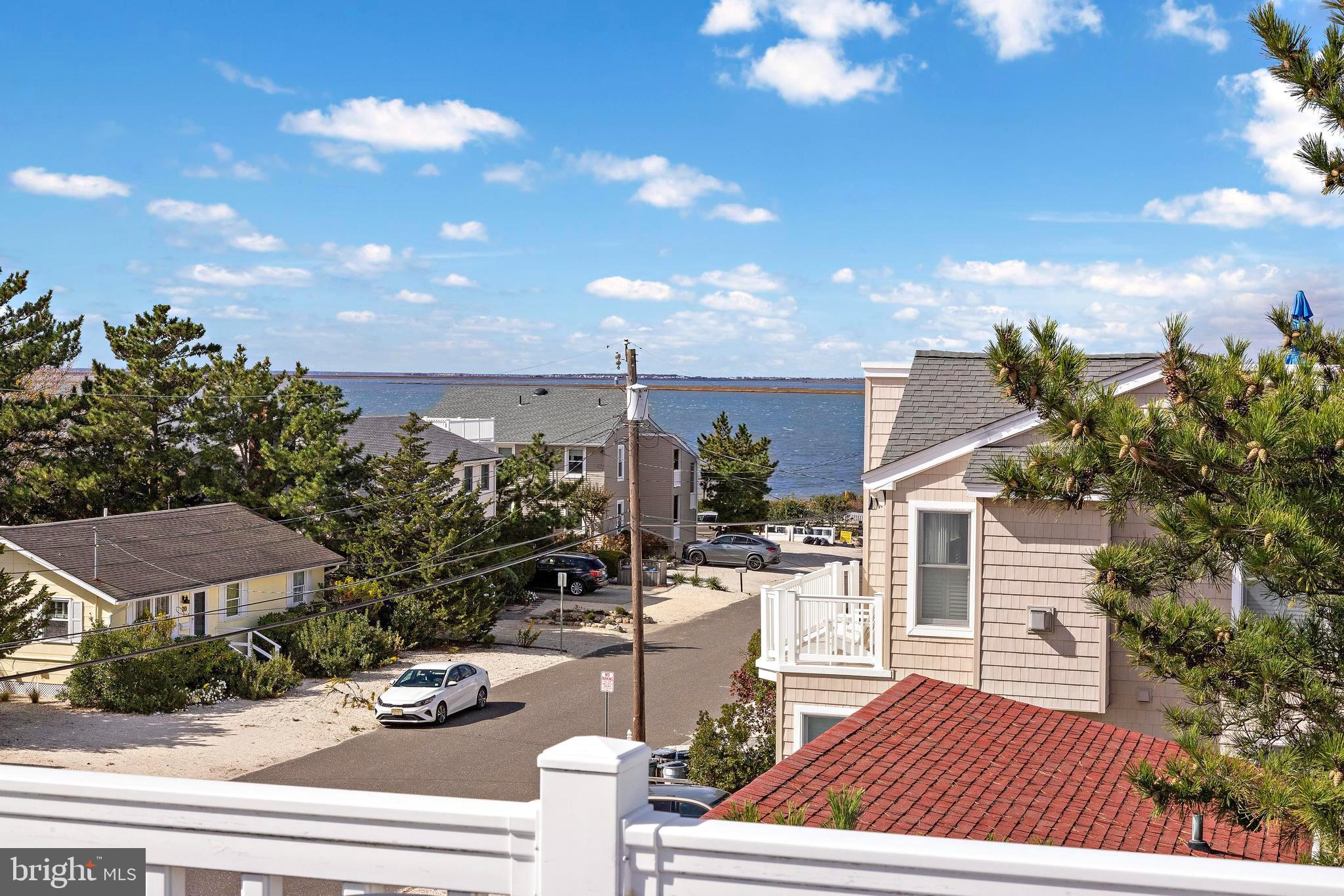 13 Joan Road, Unit 2 Long Beach Township, NJ 08008 - Photo 37 of 64 a view of a patio with table and chairs with wooden floor and fence