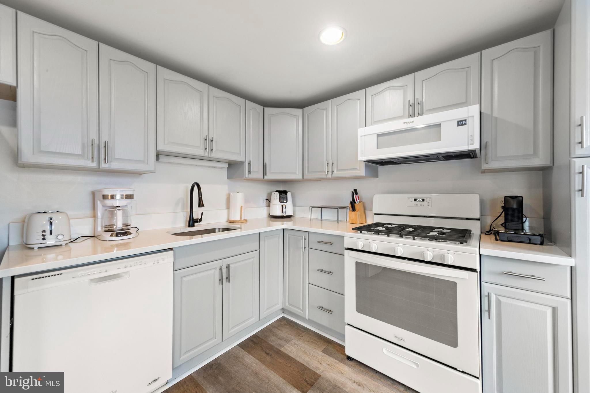 13 Joan Road, Unit 2 Long Beach Township, NJ 08008 - Photo 4 of 64 a kitchen with cabinets appliances a sink and a counter top space