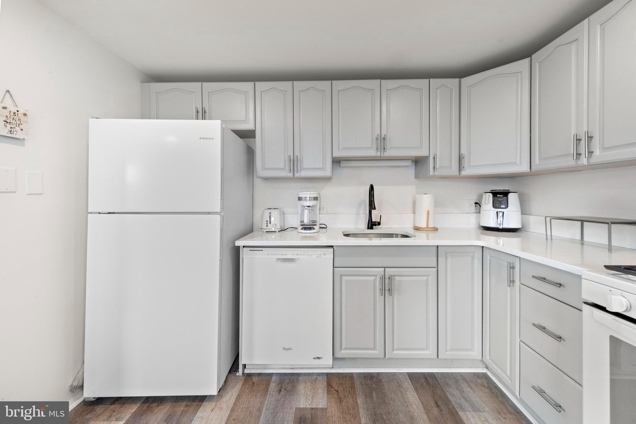 13 Joan Road, Unit 2 Long Beach Township, NJ 08008 - Photo 5 of 64 a kitchen with white cabinets and refrigerator