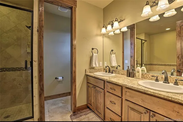 a bathroom with a double vanity sink mirror and shower