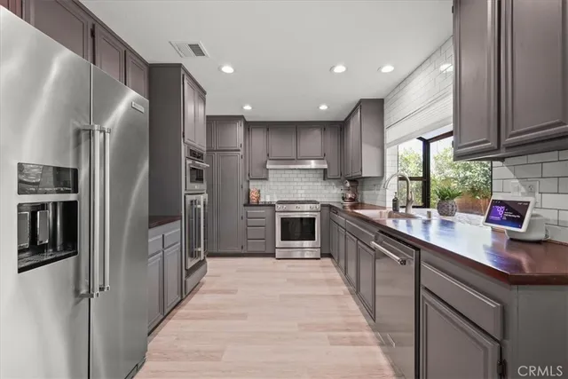 a kitchen with stainless steel appliances granite countertop a refrigerator and a sink