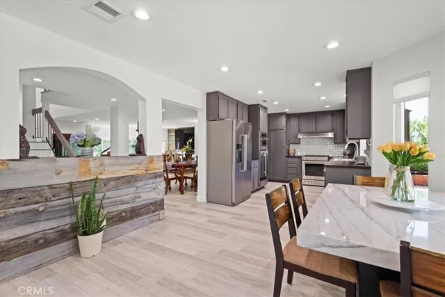 a kitchen with refrigerator and chairs