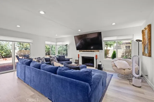 a living room with furniture a fireplace and a flat screen tv