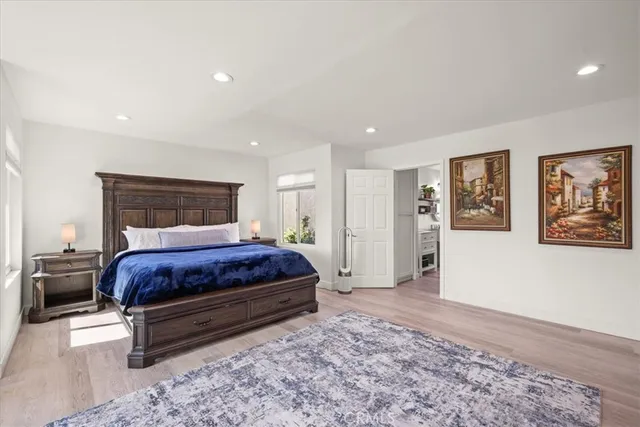 a bed sitting in a spacious bedroom next to a window