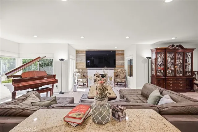 a living room with furniture flat screen tv and a large window
