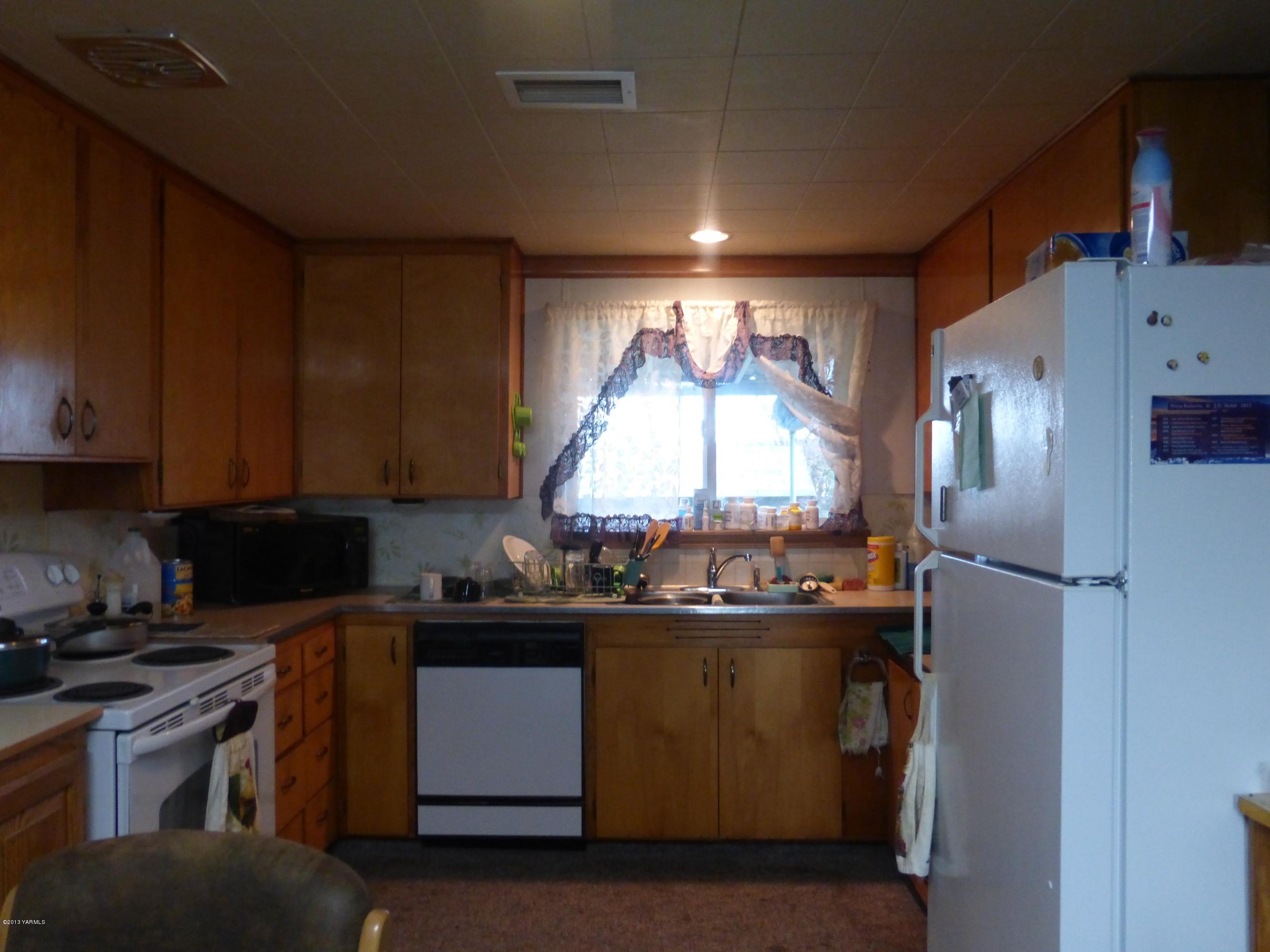 461 Barker Road Granger, WA 98932 - Photo 11 of 37 a kitchen with a sink stove and refrigerator
