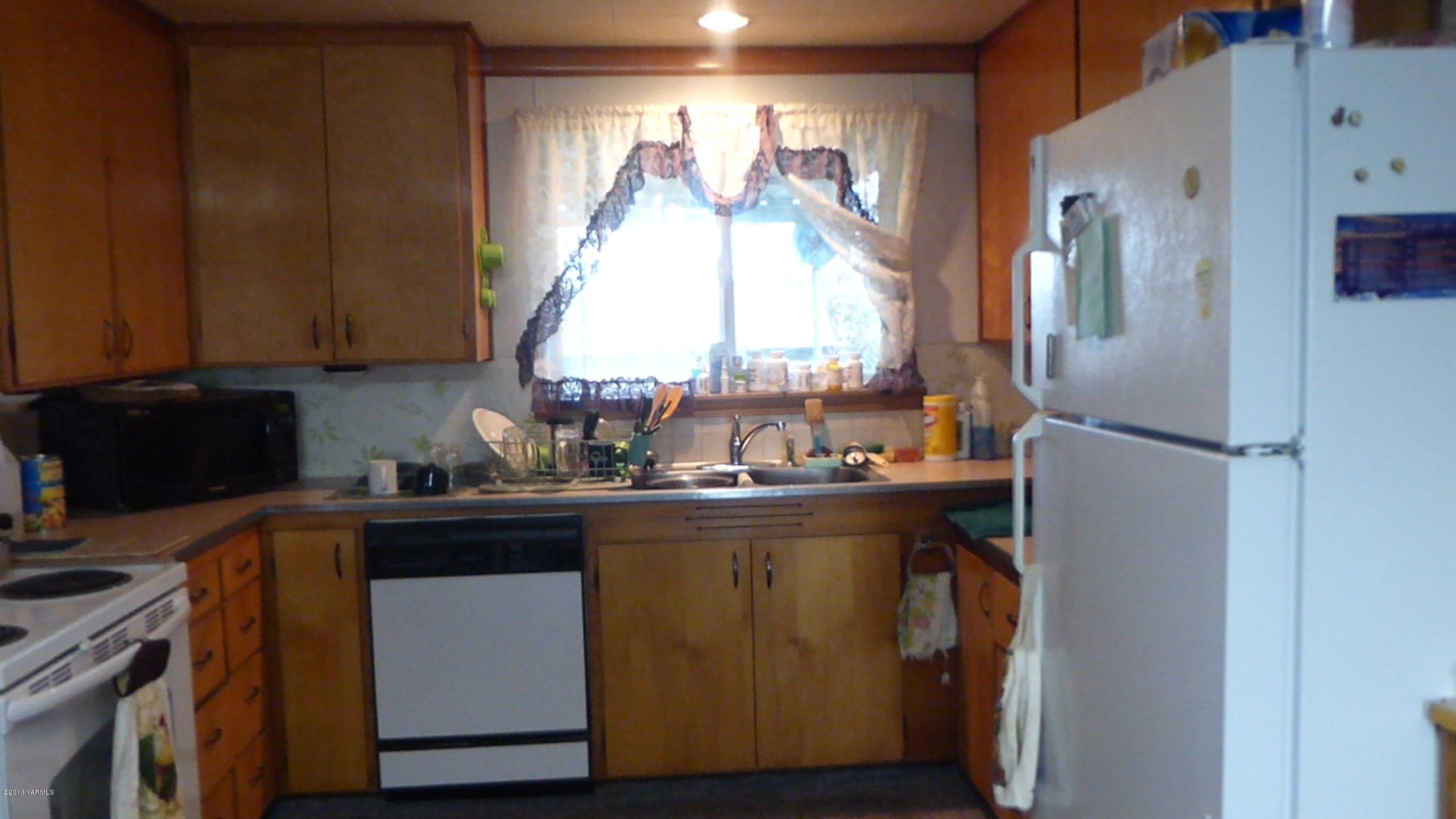 461 Barker Road Granger, WA 98932 - Photo 13 of 37 a kitchen with a refrigerator and a window