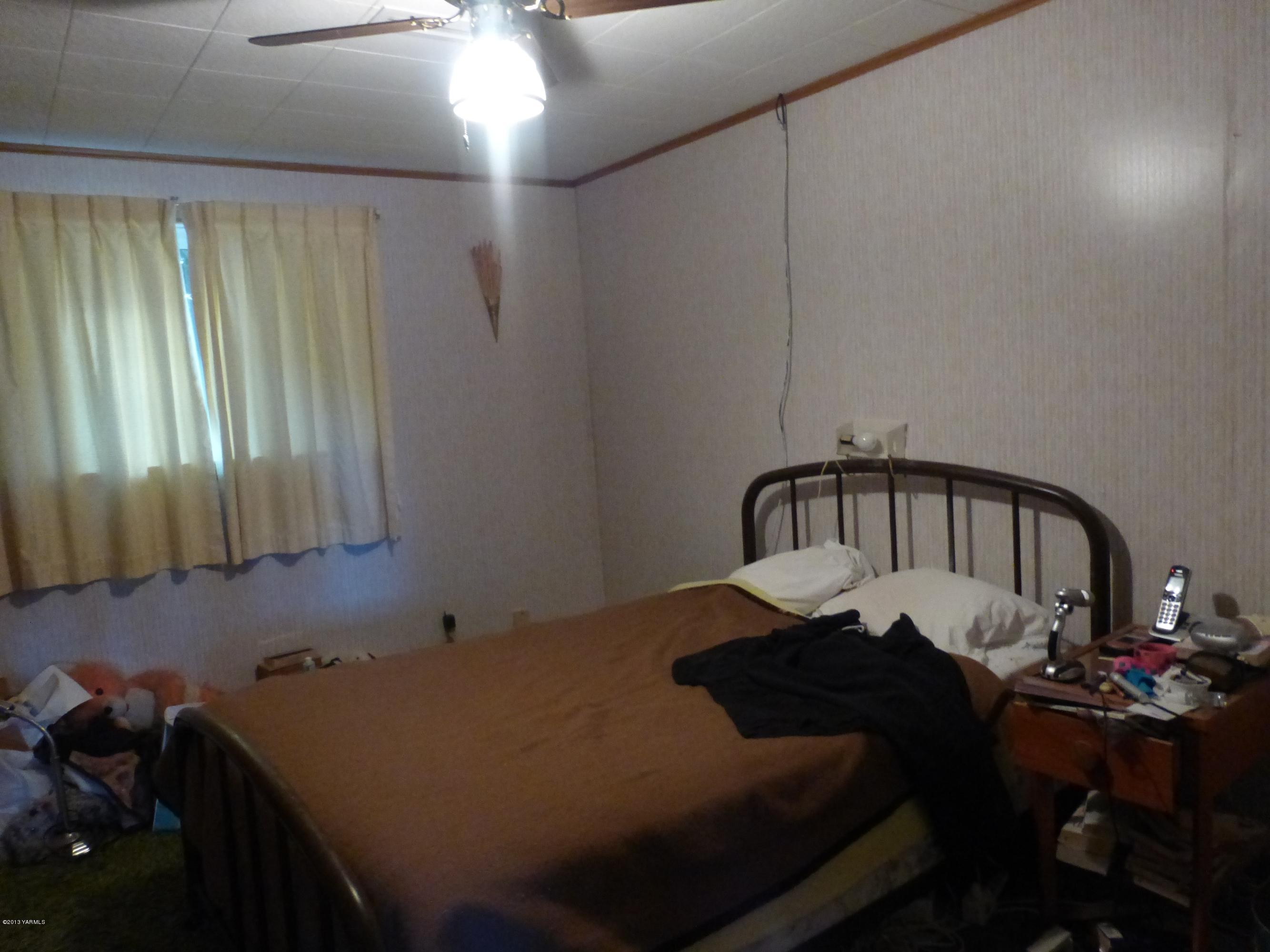 461 Barker Road Granger, WA 98932 - Photo 22 of 37 a bedroom with a bed and a chandelier