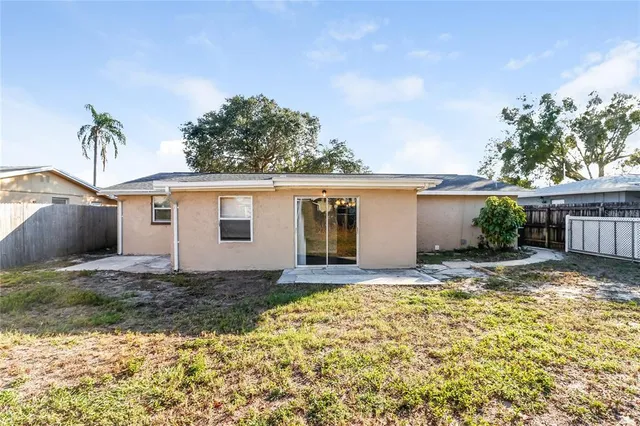 a view of a house with a yard and potted plants