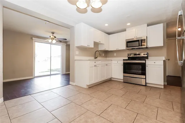 a kitchen with stainless steel appliances a sink a stove a microwave and cabinets