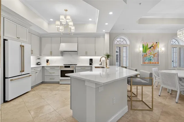 a living room with furniture a chandelier and a flat screen tv