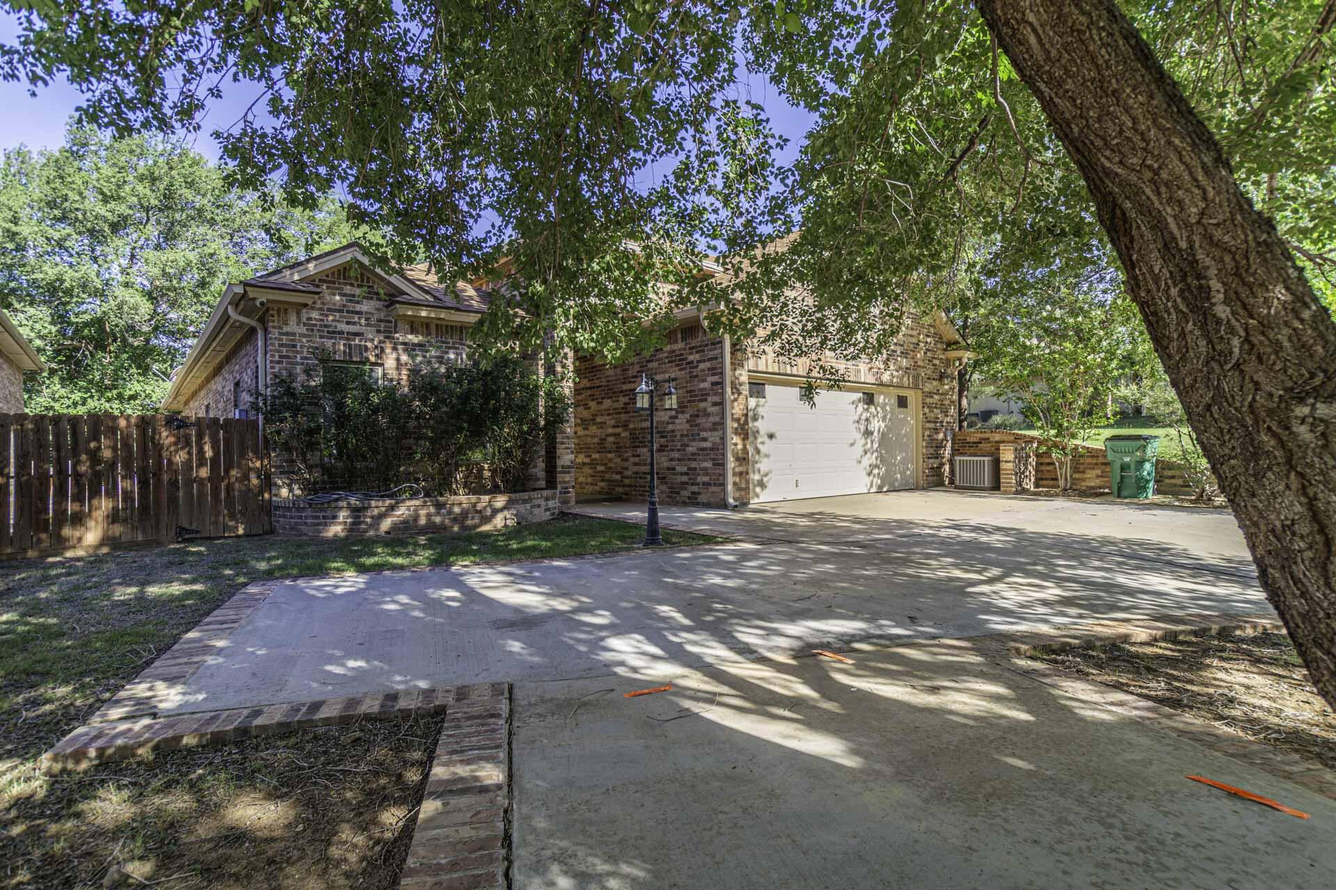 33 West Lakeshore Drive Ransom Canyon, TX 79366 - Photo 2 of 48 a view of a yard with plants and a large tree