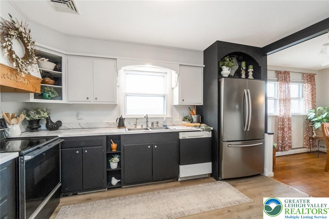 3218 Highland Road Orefield, PA 18069 - Photo 13 of 53 a kitchen with stainless steel appliances granite countertop a refrigerator a sink a stove and white cabinets with wooden floor