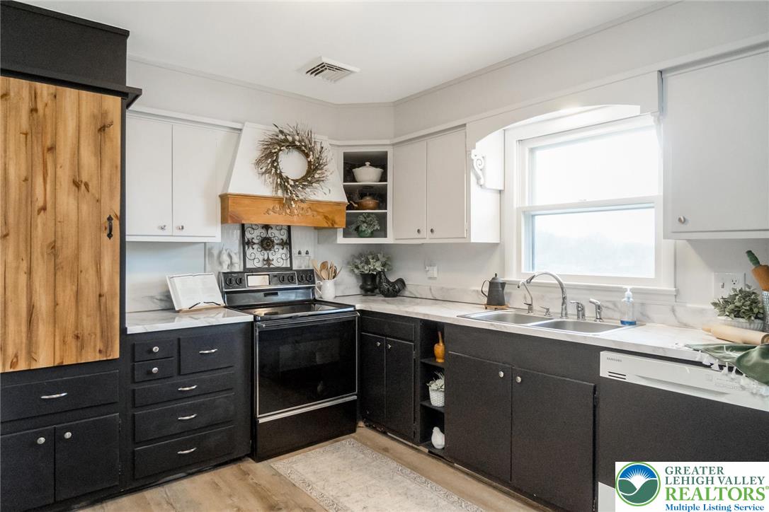 3218 Highland Road Orefield, PA 18069 - Photo 14 of 53 a kitchen with a sink cabinets a window and a potted plant