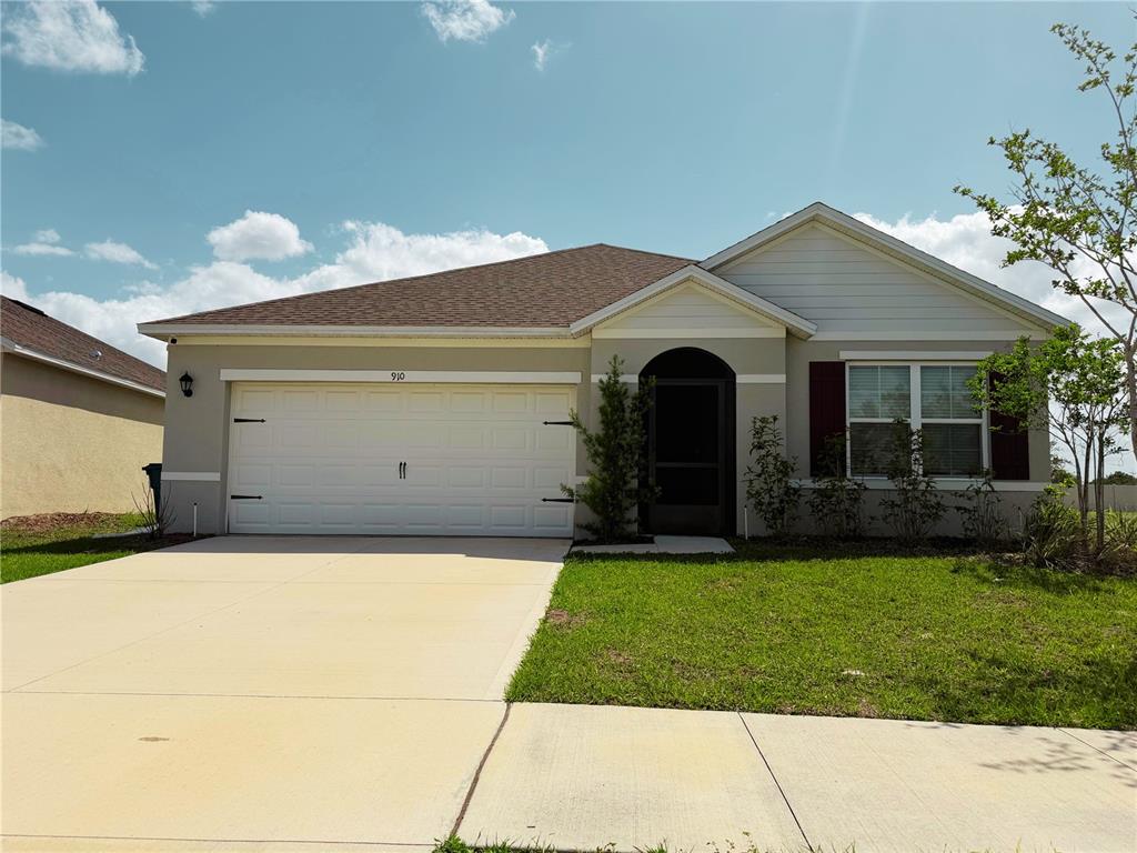 910 Sun Burst Road Winter Haven, FL 33880 - Photo 1 of 14 a front view of a house with a yard and garage
