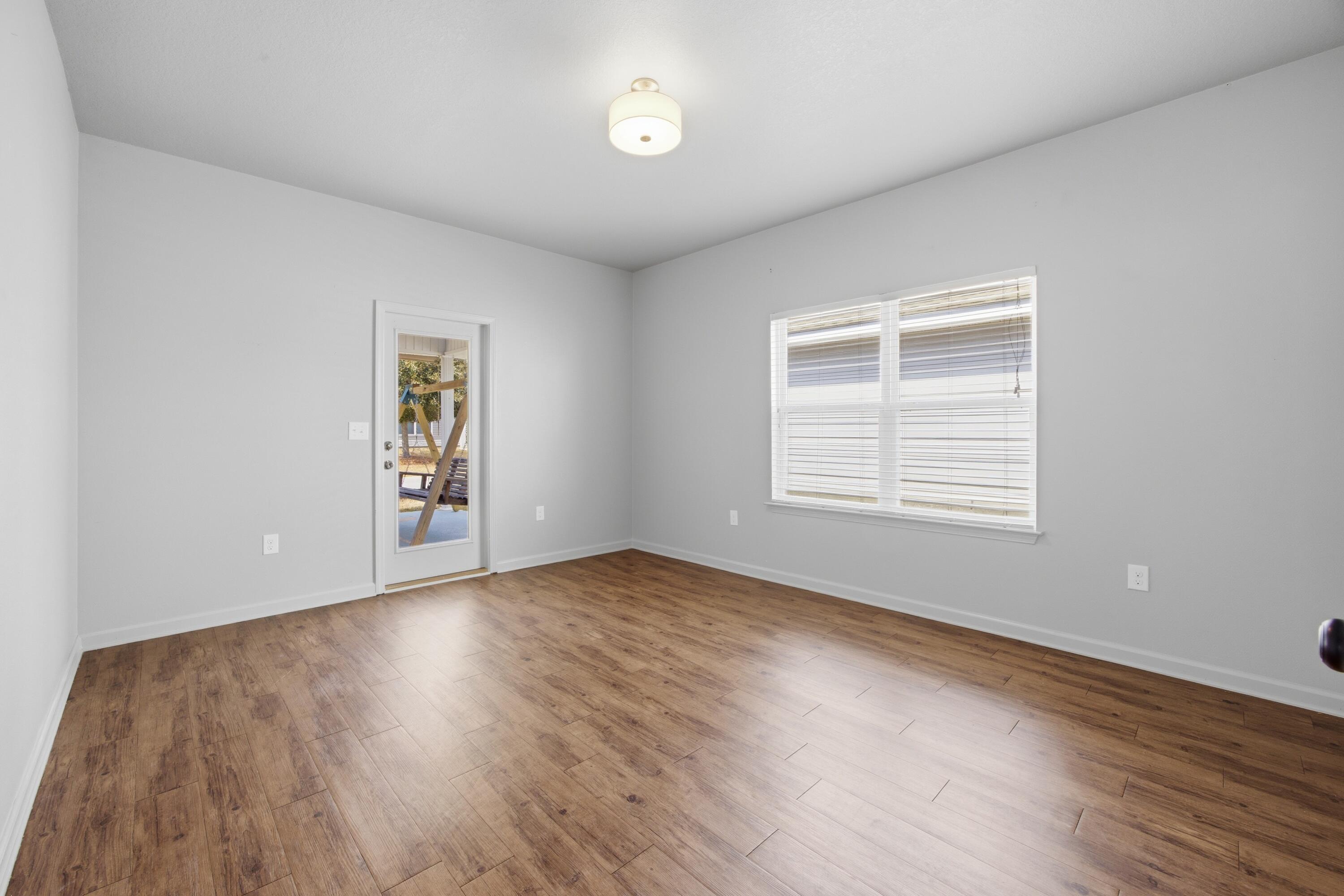 102 Cornelia Street Freeport, FL 32439 - Photo 28 of 39 an empty room with wooden floor and windows
