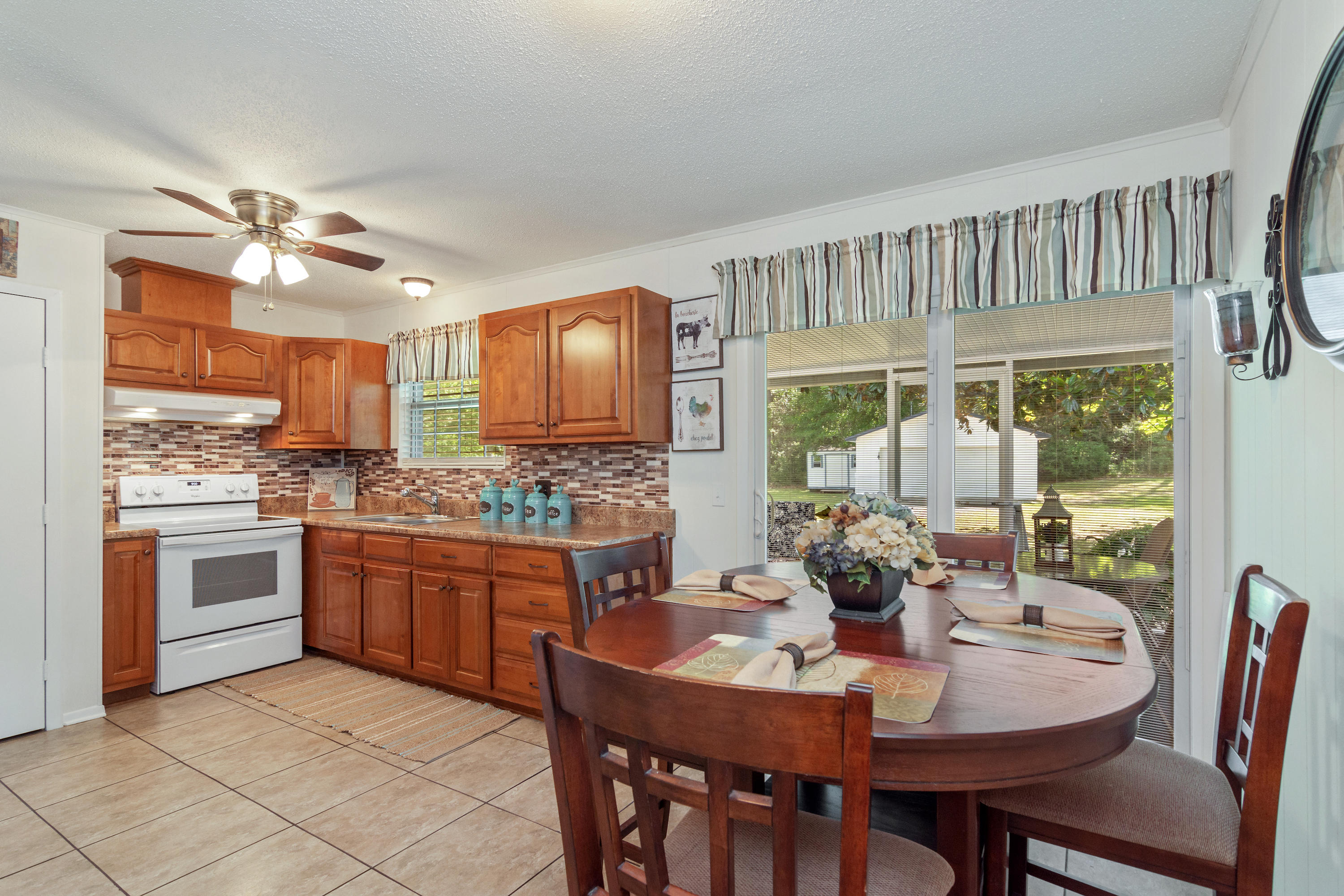 685 Ridge Lake Road Crestview, FL 32536 - Photo 14 of 30 a kitchen with stainless steel appliances granite countertop a stove a sink dishwasher a dining table and chairs with wooden floor